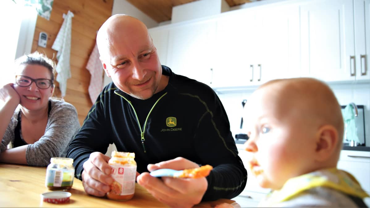 Juho Vesalainen syöttää iloisena poikaansa Otsoa. Äiti Virpi Lappi katsoo vieressä hymyillen.