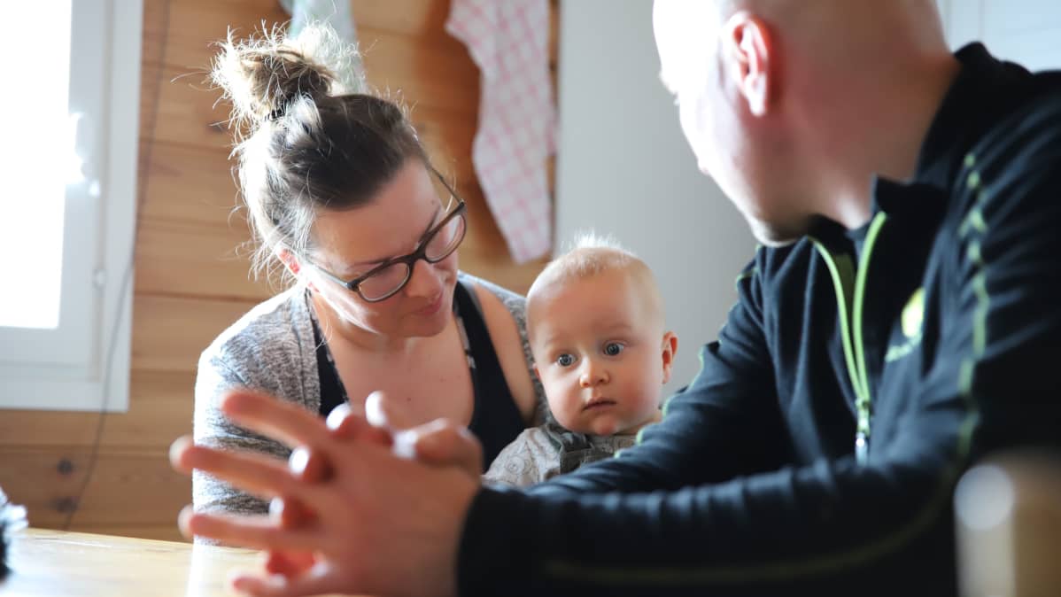 Virpi Lappi pitää sylissään poikaansa Otsoa. Otso katsoo vakavana kameraan.