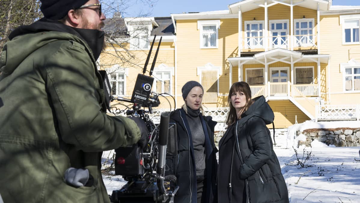 Näyttelijät Sofia Pekkari ja Pihla Viitala televisiosarjan kuvauksissa vanhan kartanon lumisella pihalla.
