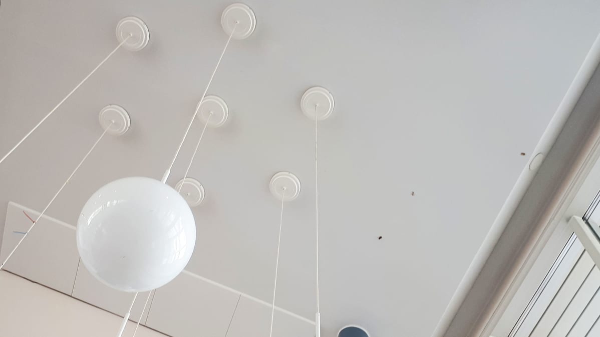 Raumon koulun ala-aulan katto, johon on heitetty käytettyjä nuuskapusseja.