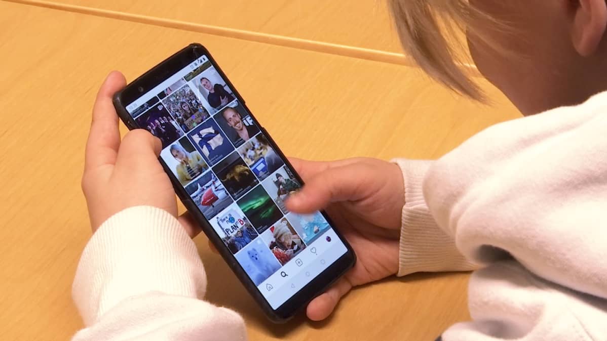 Lapsi selaa Instagramia puhelimella.