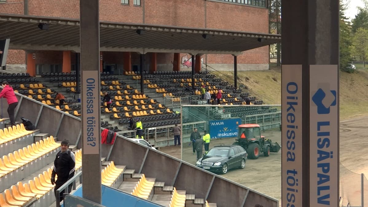 Talkoolaiset siivoaa pesäpallostadionin katsomoa