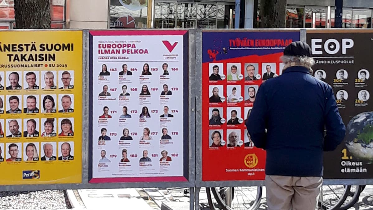 Mies katsoo EU-vaalimainoksia kadulla.