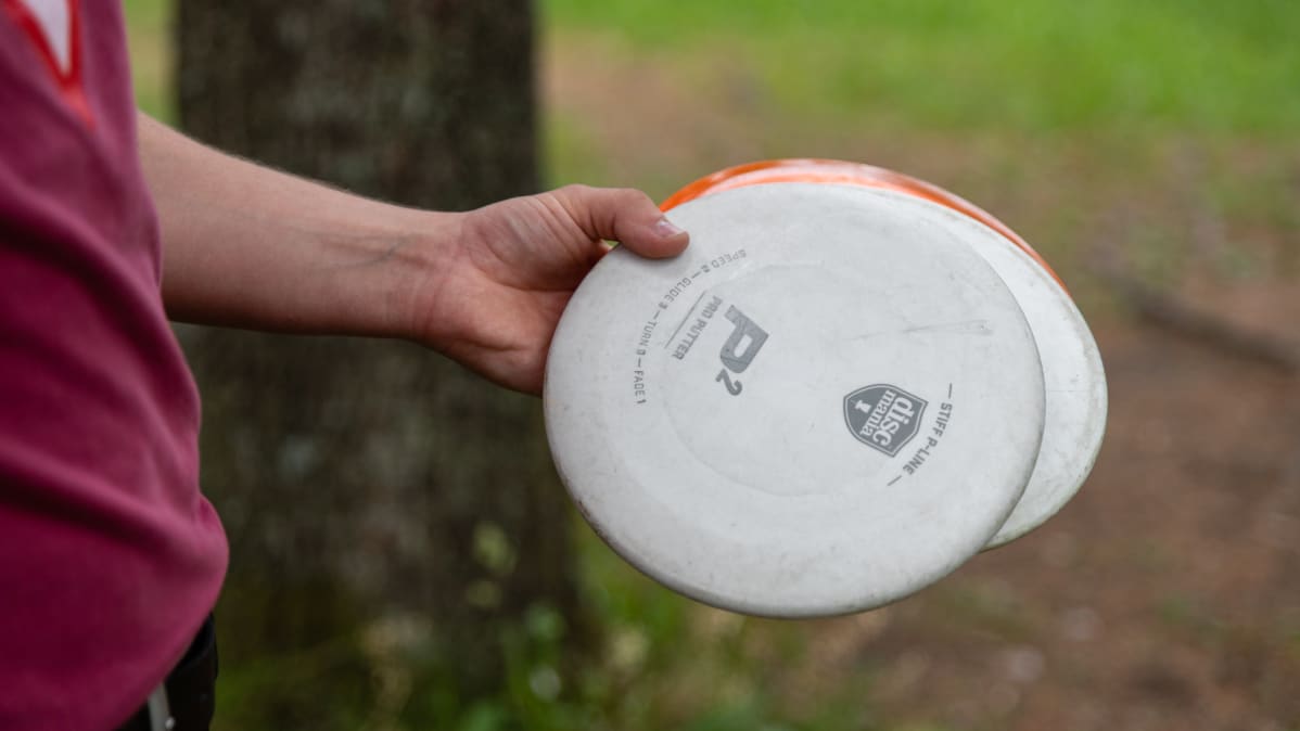 Frisbeegolf-kiekkoja kädessä
