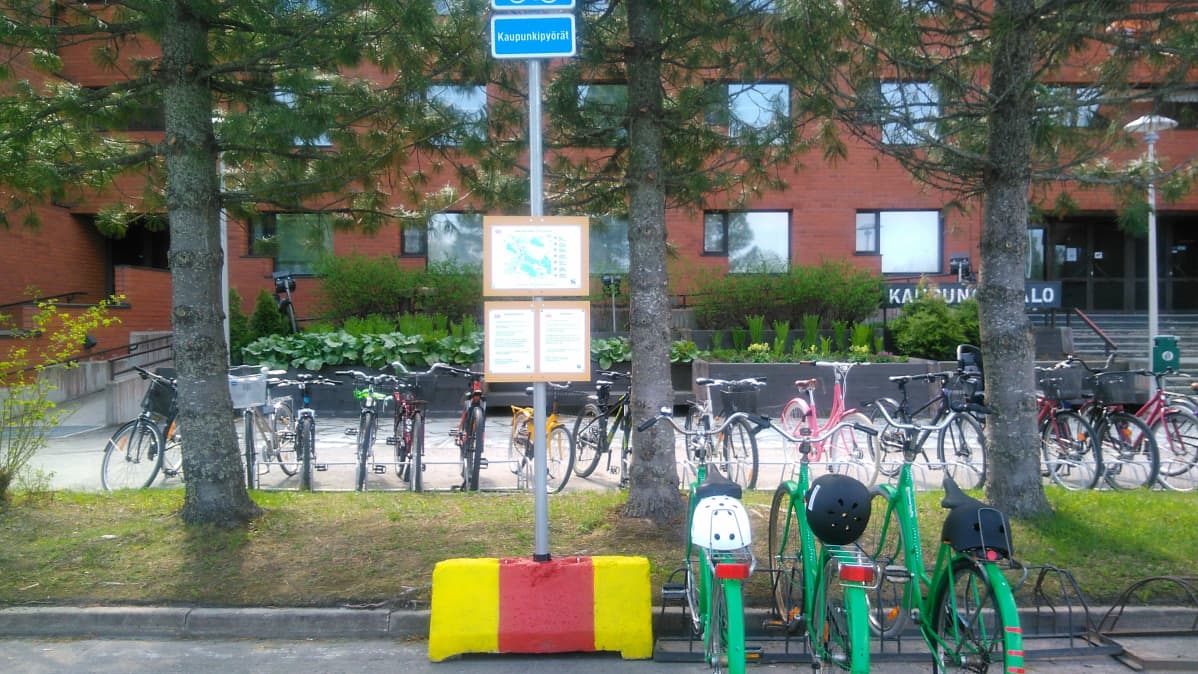 Kolme pyörää parkissa Kuusamon kaupungintalon edustalla.
