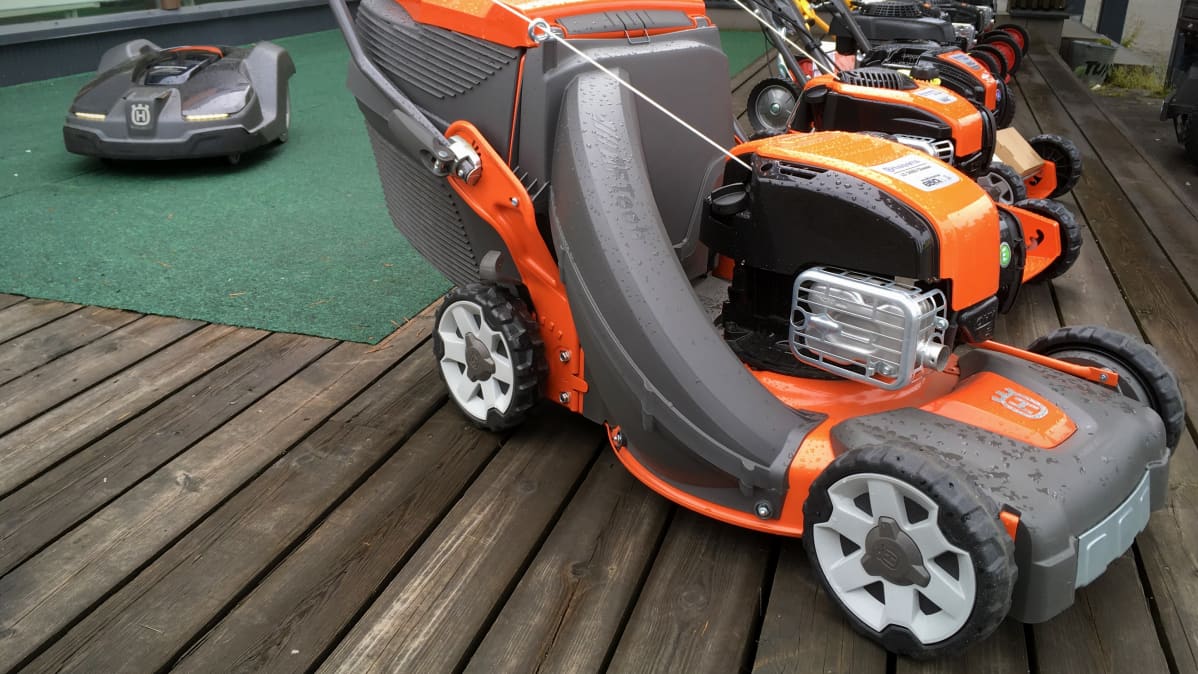 Robottiruohonleikkuri ja perinteisiä polttomoottoriruohonleikkureita esillä myymälän pihamaalla.