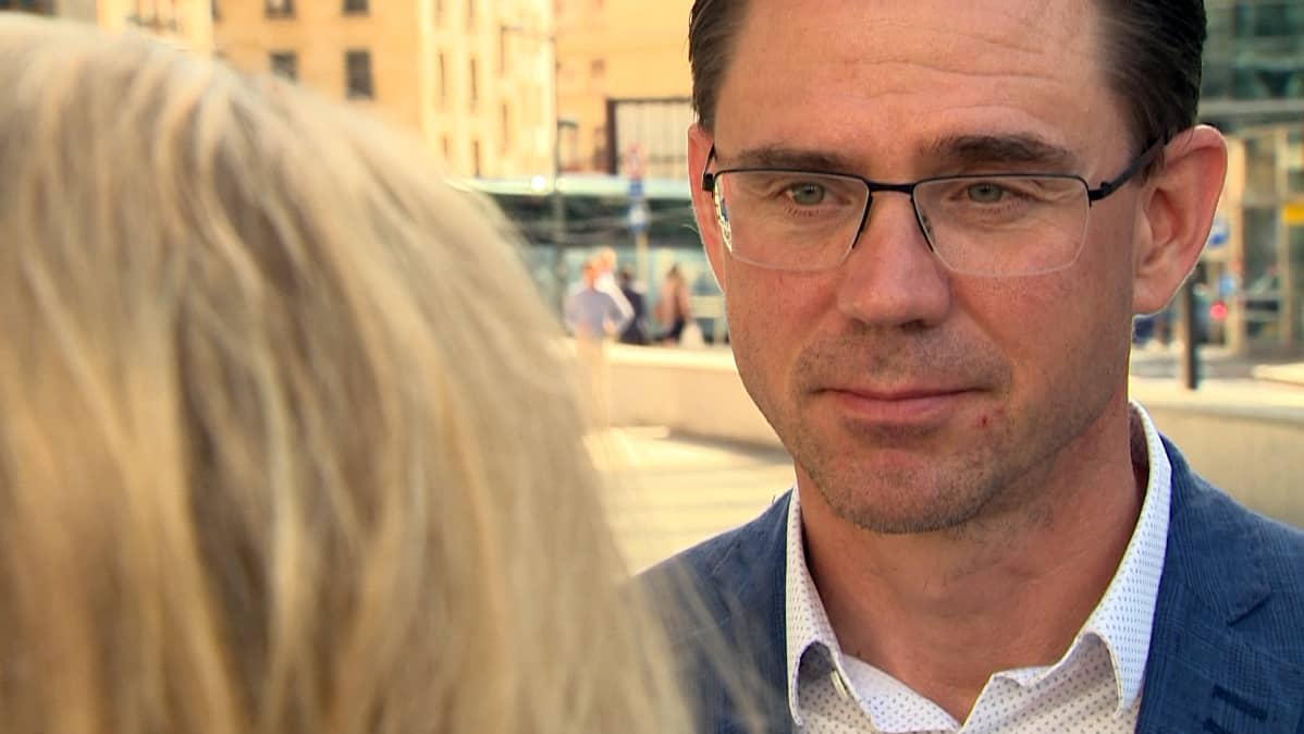 Jyrki Katainen keskustelee toimittajan kanssa kadulla.