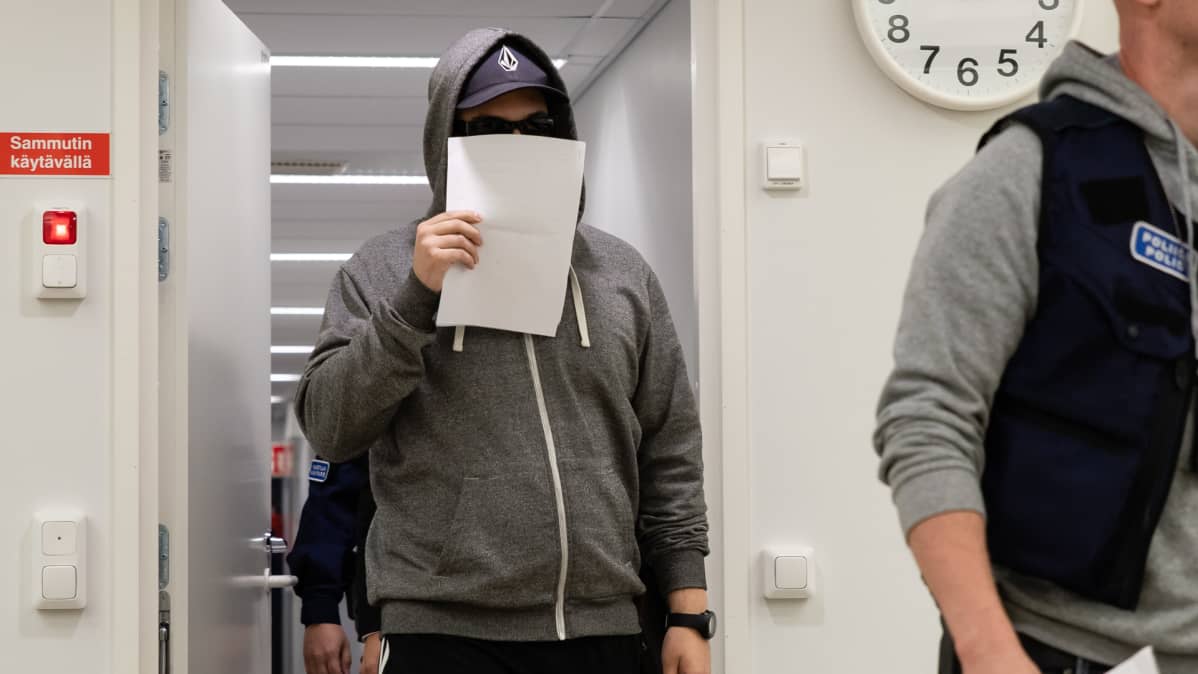 Murhasta syytetty mies kävelee Etelä-Karjalan käräjäoikeuden istuntosaliin 9.8.2019.