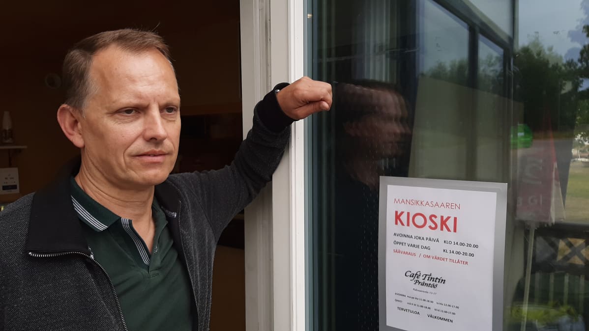 Mies seisoo kioskiin nojaten.