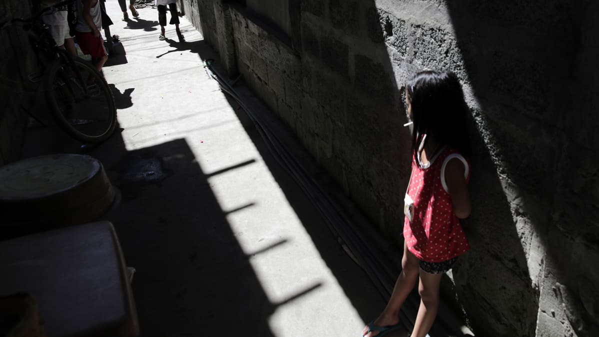 Tyttölapsi kuvattuna kujalla Manilan slummissa helmikuussa 2019.