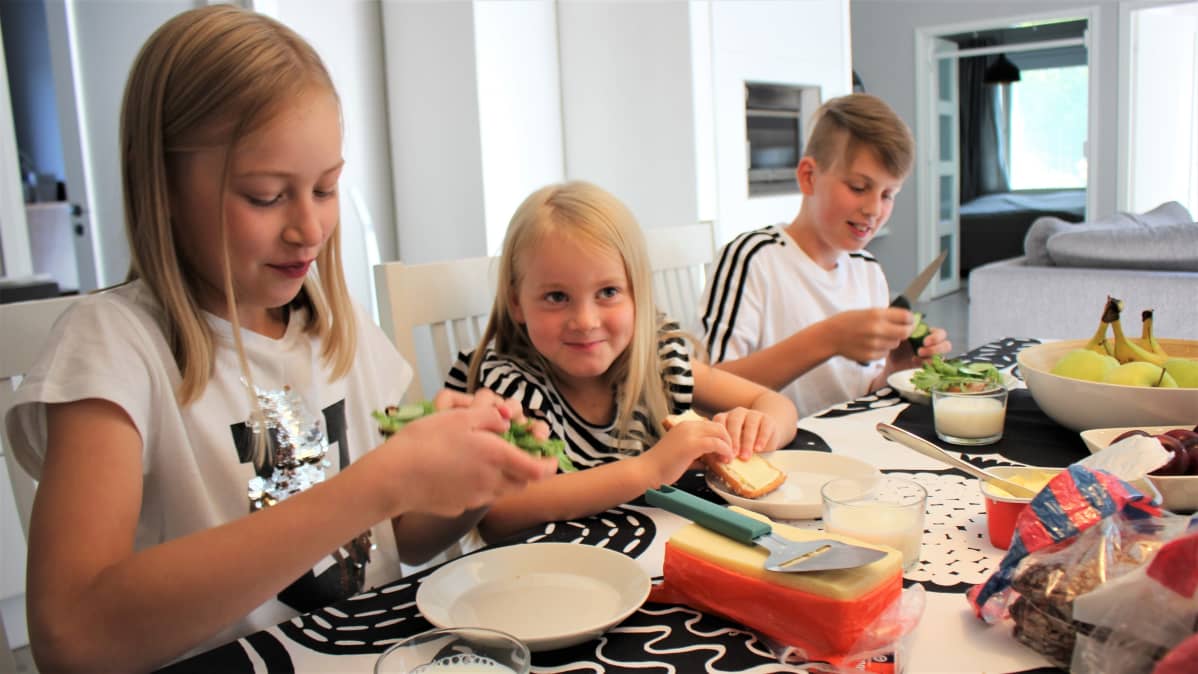 Pesosten perhe välipalalla.