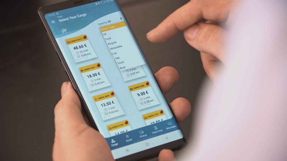 Henkilö käyttää mobiiliapplikaatiota puhelimellaan