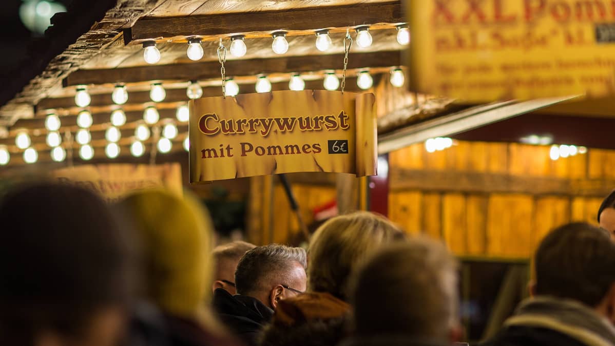 Mainoskyltissä myytiin 'Currywurstia ranskalaisten kera' joulumarkkinoilla Saksassa.