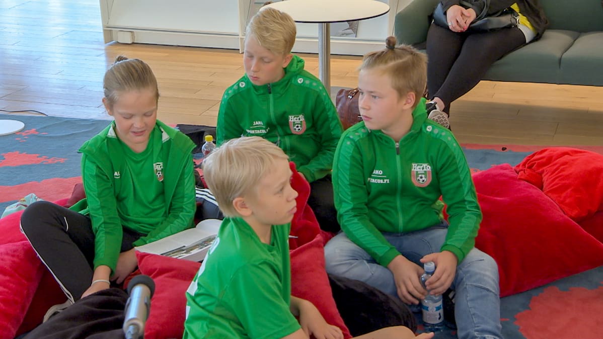 Herttoniemen Tovereitten Sudet (s. 2007) jalkapallojuniorit lukevat Litmanen 10 -kirjaa lattialle levitetyillä punaisilla tyynyillä keskustakirjasto Oodissa 1.8. 2019 Puoli seitsemän -ohjelman Lukuhaaste-tempauksessa, (v-o Paavo Pulkkinen, Touko Sorsa, Jare Mäkinen, Kosmo Kähönen).