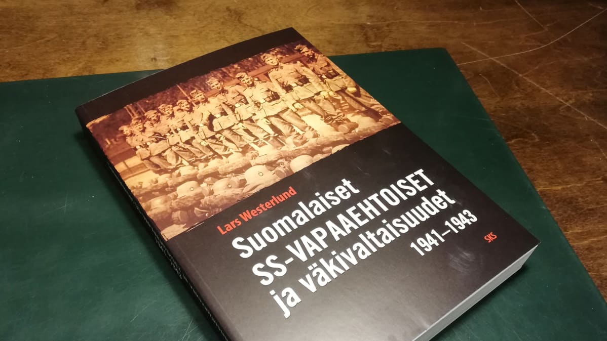Suomalaiset SS-vapaaehtoiset ja väkivaltaisuudet 1941–1943 -kirja pöydällä.