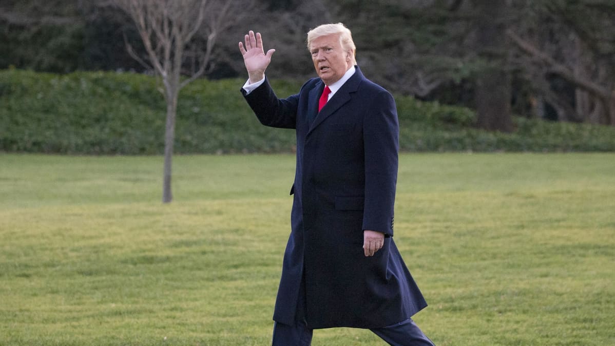 Donald Trump kävelee Valkoisen talon nurmikon poikki.