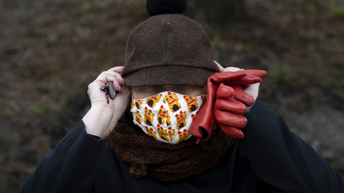Hengityssuojaimeen pukeutunut nainen.