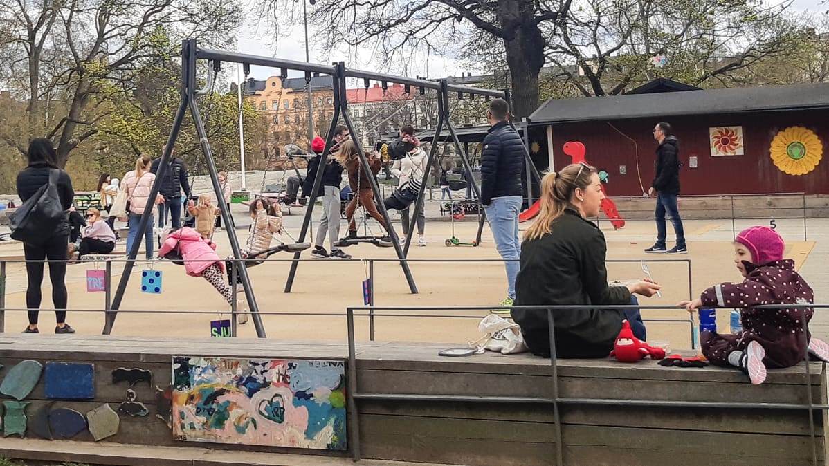 Ihmisiä lasten leikkipaikalla.