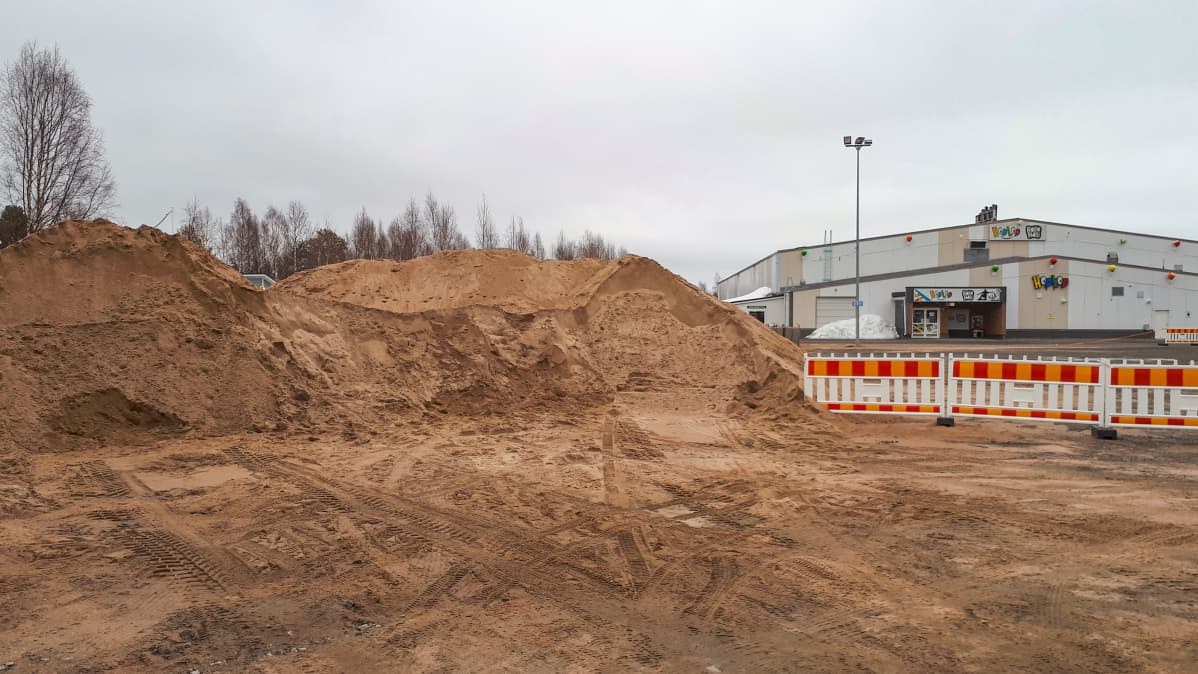Rollohallin pihassa Rovaniemen Saarenkylässä on muhkeat läjät hiekkaa.