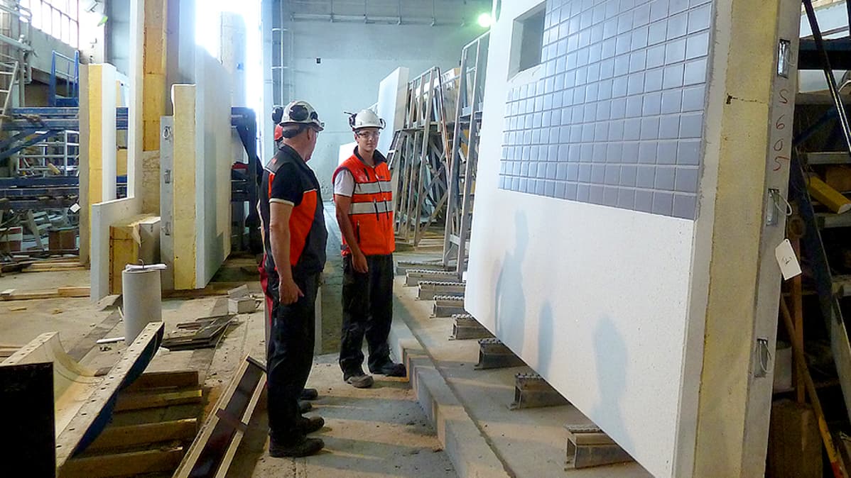 Lujabetonin työntekijät tarkastelevat valmista elementtiseinää