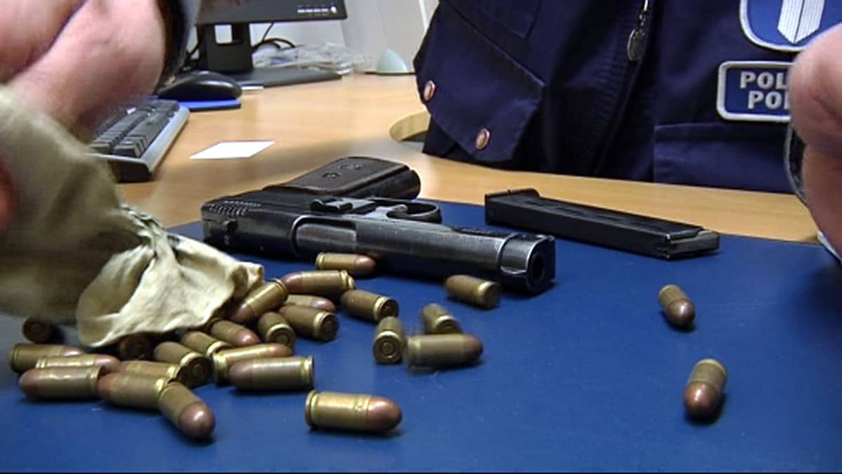 Pistooli ja patruunoita poliisin pöydällä.