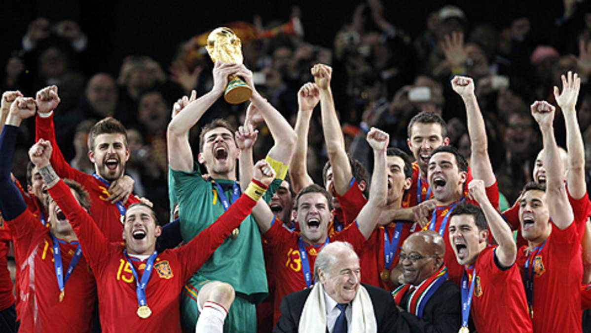 Espanjan maalivahti Iker Casillas nostaa pokaalin ilmaan joukkueen voitettua jalkapallon MM-kisojen finaalin Etelä-Afrikassa. Joukkue riemuitsee vierellä.