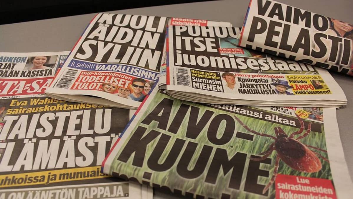 Iltapäivälehtiä levällään pöydällä.
