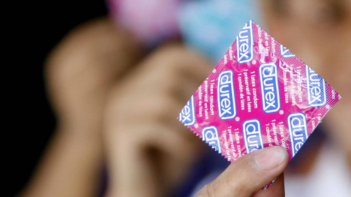 Henkilö pitelee käsissään Durex kondomipakettia.