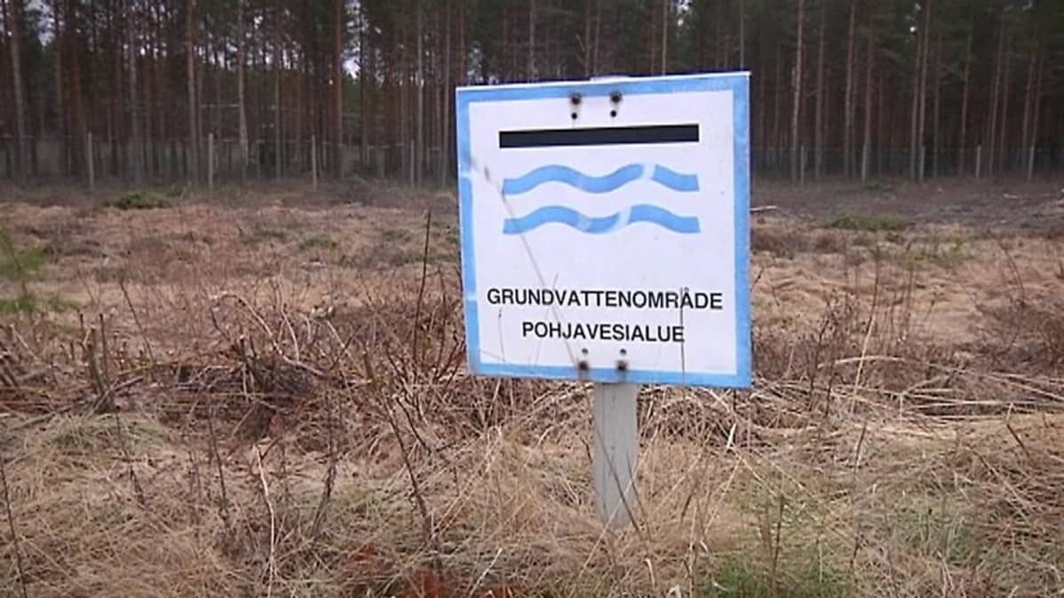 Pohjavesialueesta kertova kyltti maastossa.