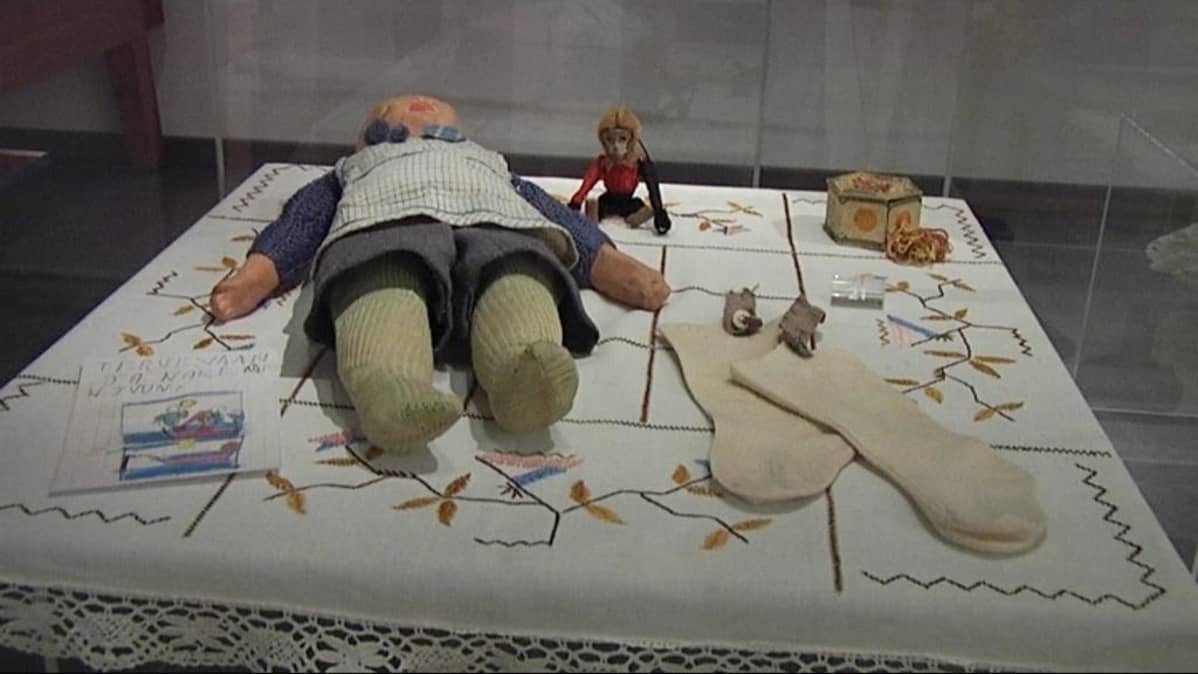 Lahden historiallisen museon vitriinissä on leluja, puuterirasia ja sukat.