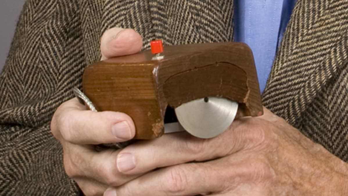 Tietokonehiiren keksijä Douglas Engelbart käsissään hiiren yksi ensimmäisistä versioista.