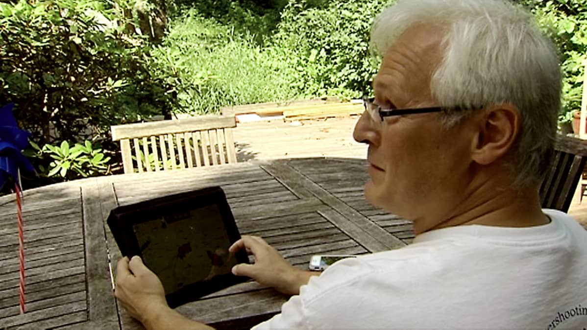 Janne Kommonen puutarhassaan iPadin ääressä.