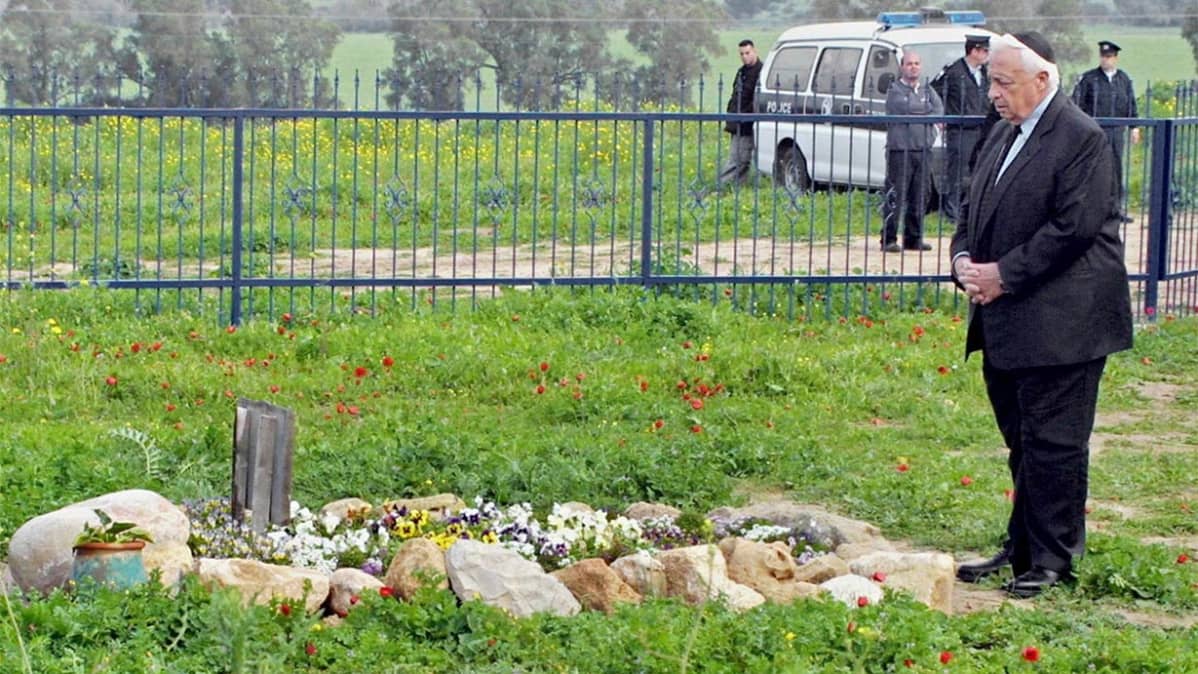 Ariel Sharon seisoo kivisen haudan edessä.