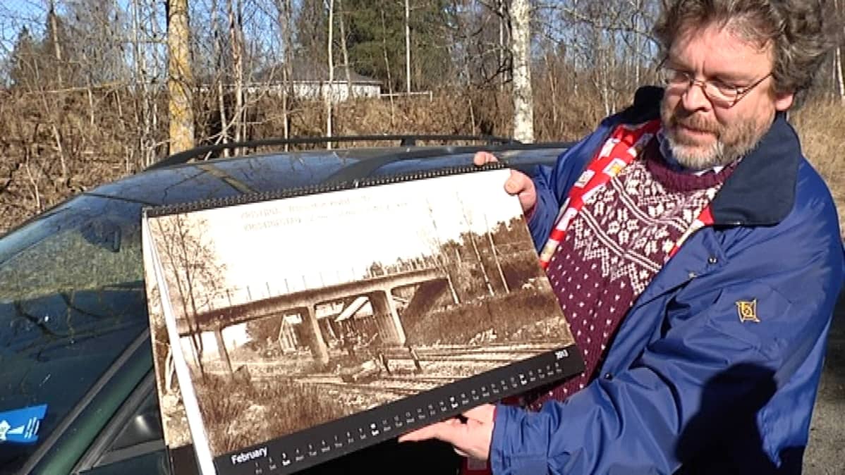 Jarkko Ikkelä-Koski esittelee Kristiinankaupungin rautatiesillan vaiheista tehtyä kalenteria.