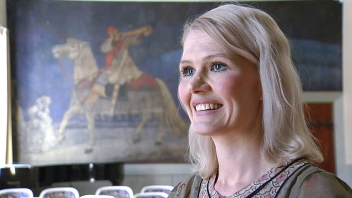 Historioitsija Jenni Kirves ja taustalla Akseli Gallen-Kallelan Kullervon sotaan lähtö -maalaus.