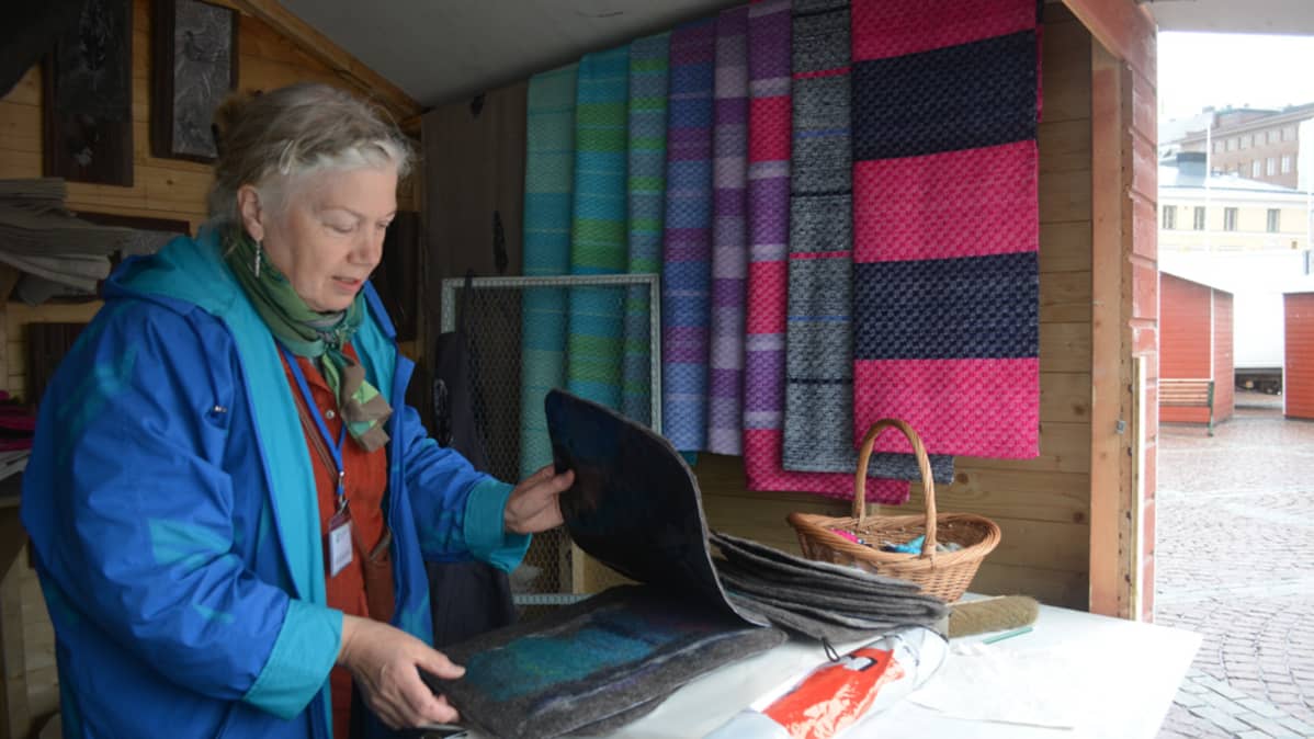 Sotkamolainen Leila Viitala järjestelee käsitöitään myyntikojussaan.