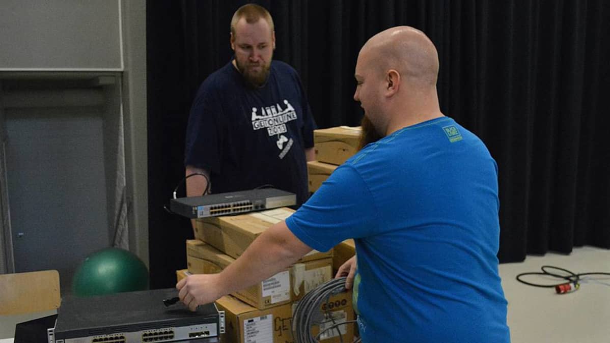 Kaksi miestä rakentamassa verkkopelitapahtumaa