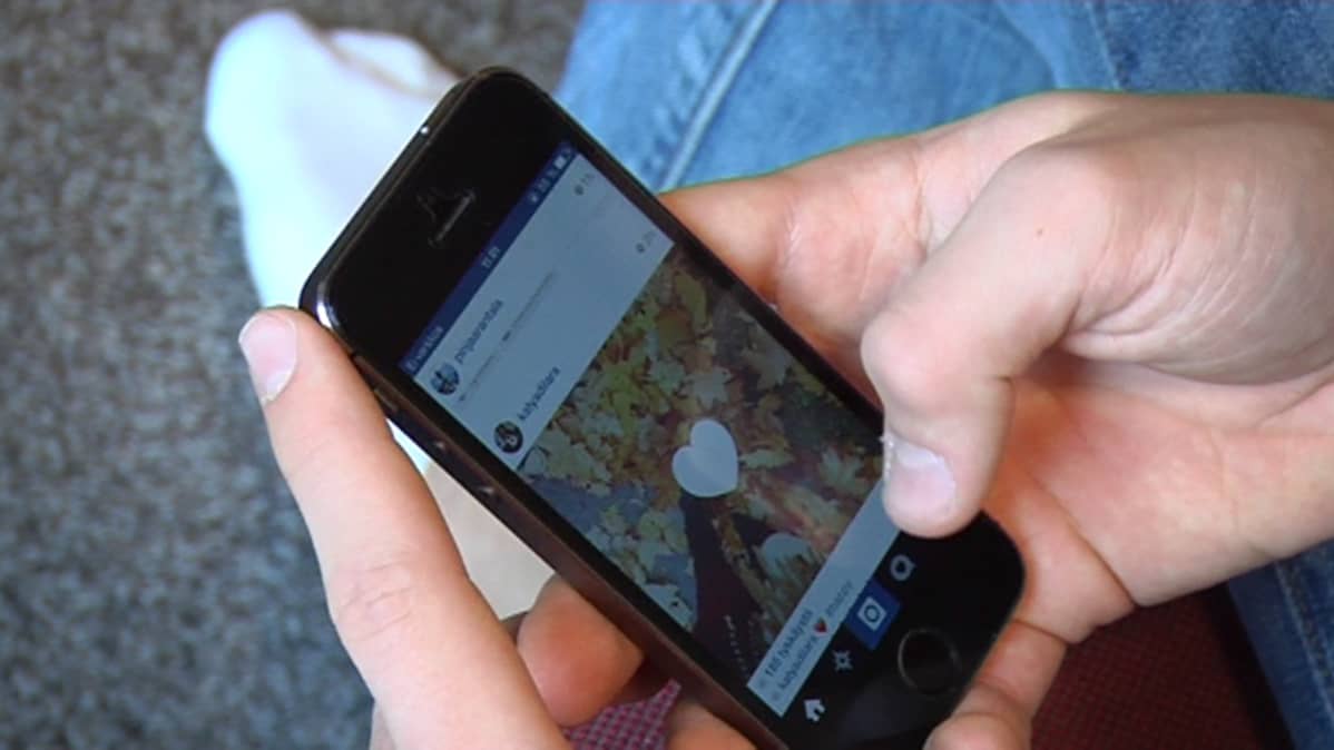 Nuori selaa älypuhelimella Instagramia.