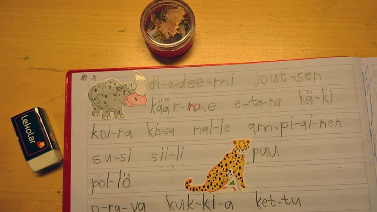 Ekaluokkalaisen vihko, jossa kirjoitusharjoituksia.