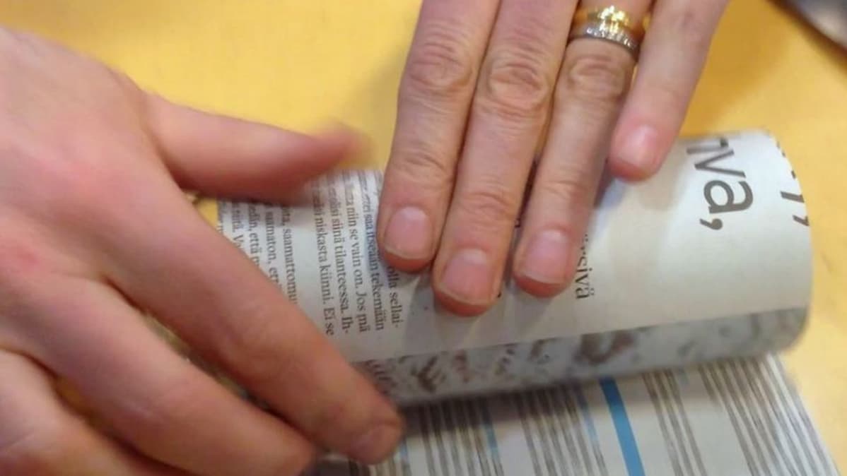 Sanomalehtipaperista muotoillaan taimipurkkia lasipurkin päälle
