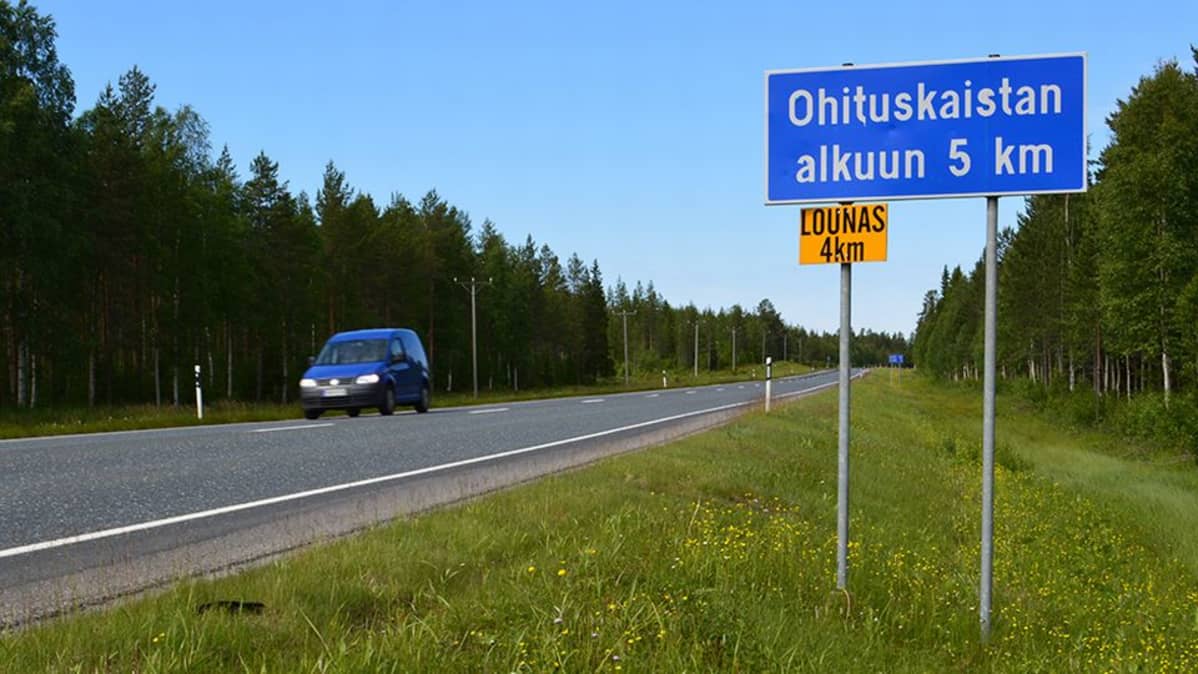Tienvarren liikenneopasteeseen kiinnitetty keltainen mainoskilpi.