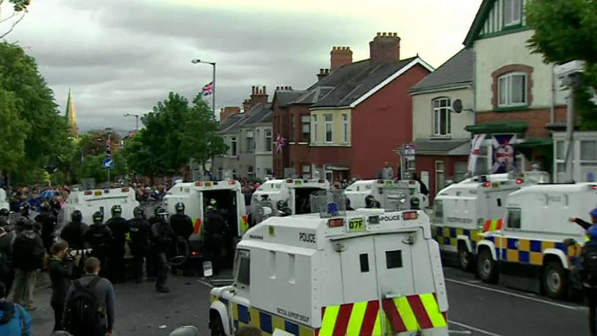 Poliiseja ja mielenosoittajia lojalistien marssin aikana Belfastissa.