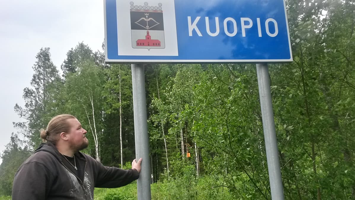 Mies ja Kuopion kyltti.