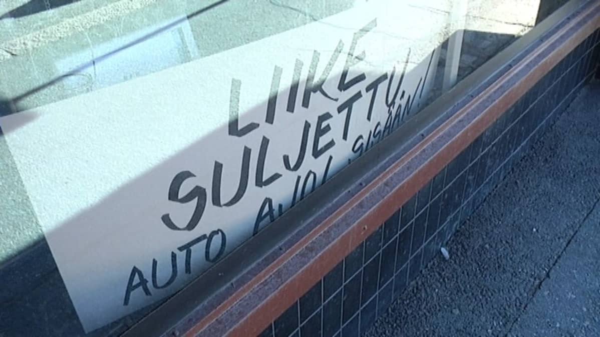Nappikaupan näyteikkunassa kyltti.