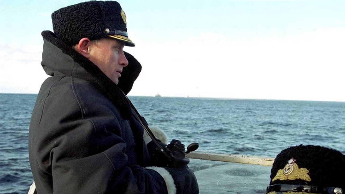 Putin kiikarit kädessä laivan kannella.