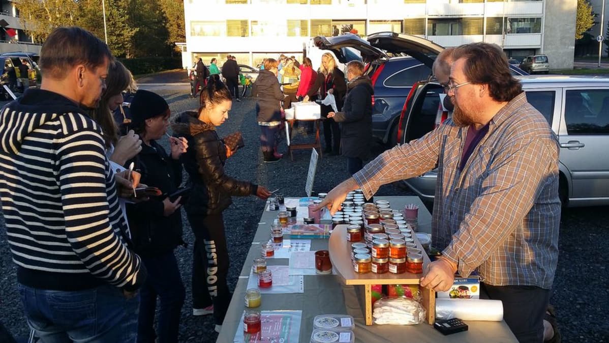Kuvassa mies myy hunajaa Kokkolan Reko-lähiruokapiirissä.
