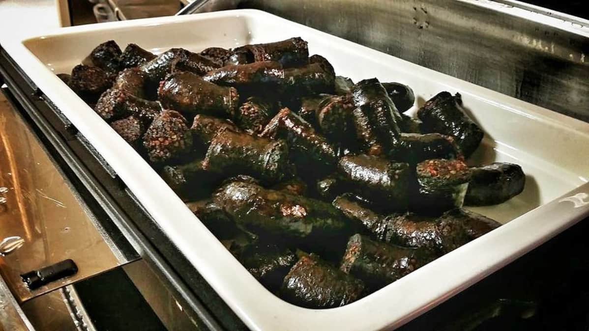 Mustaamakkaraa tarjolla aamiaispöydässä valkeassa vadissa.