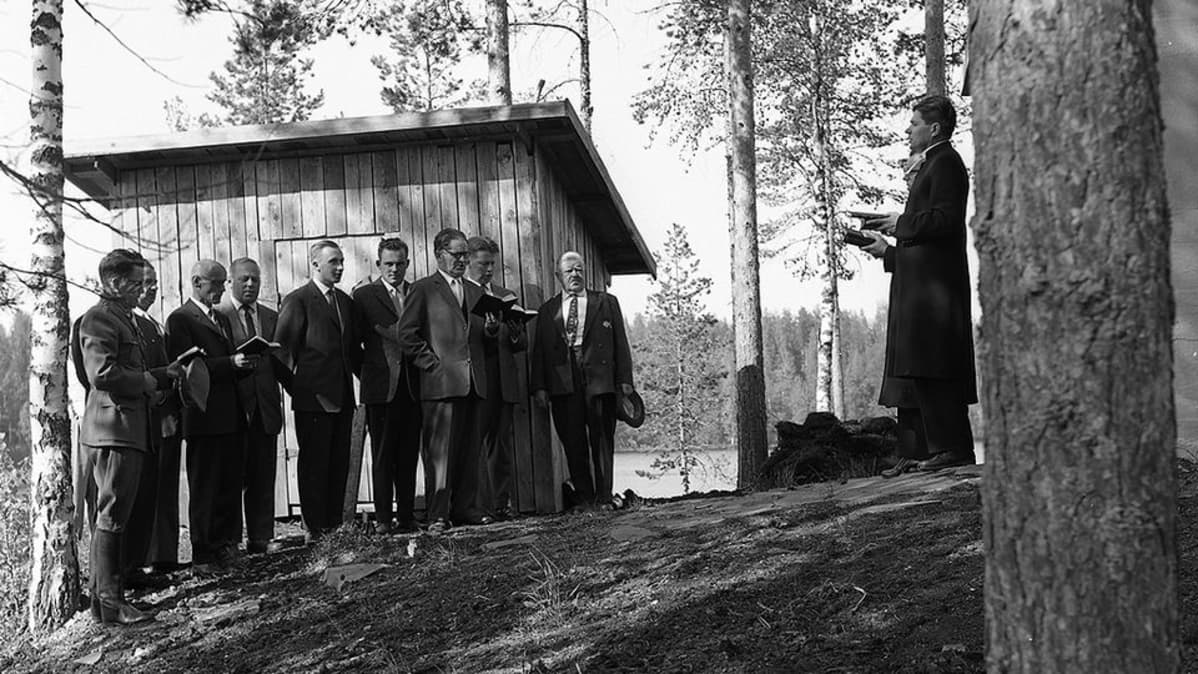 Rautjärvi, Iivansaari, hautausmaan siunaustilaisuus 1961.
Keskellä kuvaa jääkärivääpeli Johan Erik Reinikainen.