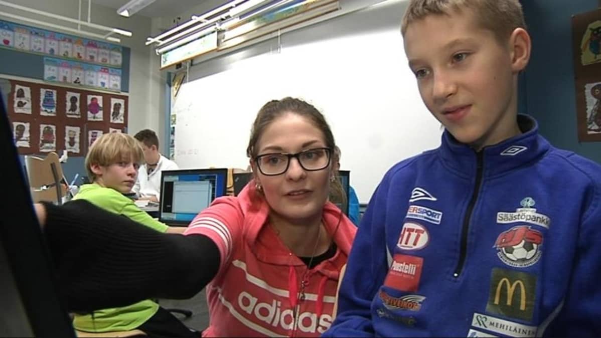 Emmi Lehto opastaa poikaa koodikerhossa