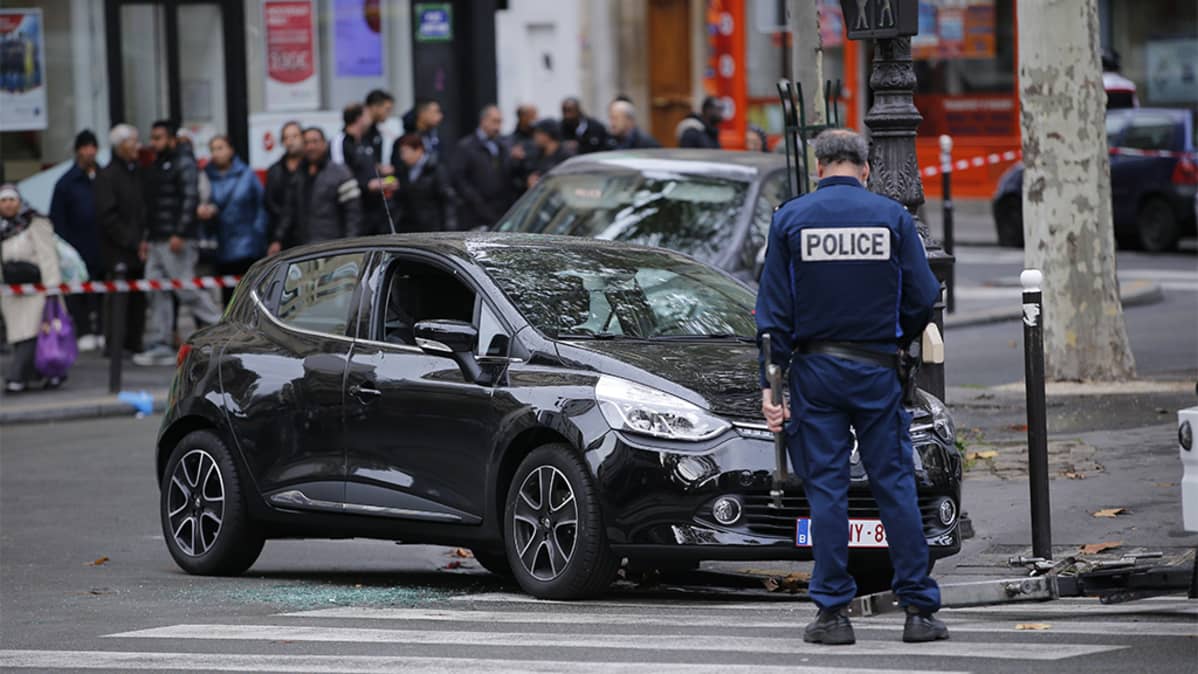 Poliisi osittain suojatien päälle pysäköidyn auton luona.